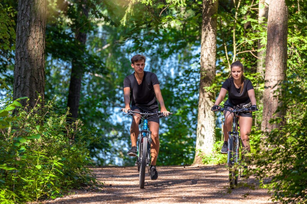 Para jadąca na rowerach w lesie