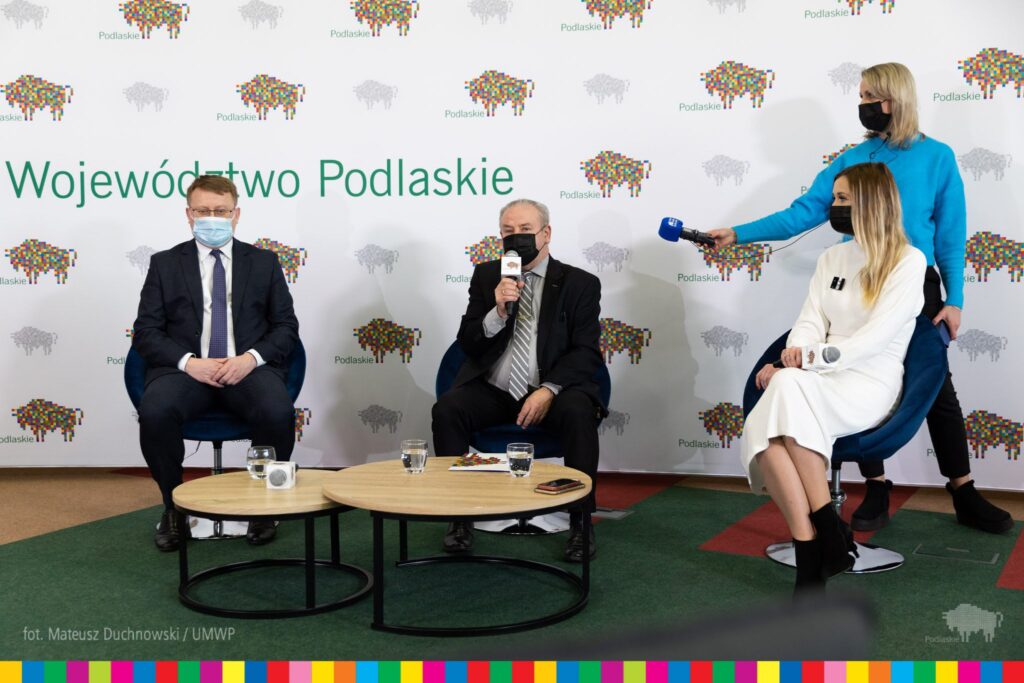 panel dyskusyjny przemawia Marek Olbryś, obok siedzi Mariusz Dąbrowski, dziennikarka Radia Białystok i rzecznik prasowy Izabela Smaczna